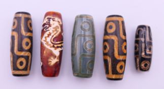Five agate dzi beads. The smallest 3 cm long.