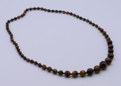 A tiger's eye beaded necklace. 66 cm long.