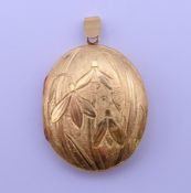 An 18 ct gold locket engraved with snowdrops. 4.5 cm high including suspension loop 18.6 grammes.