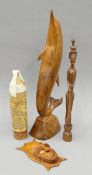 Four various Papua New Guinean wooden carvings, including a dolphin. The latter 49 cm high.