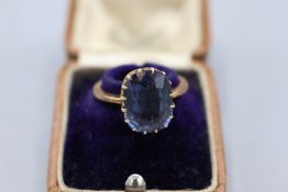 18ct yellow gold ring, set with a cushion-cut faceted purple stone, tests sapphire, measuring