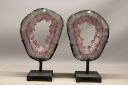 Pair of amethyst portal geodes on stands, comprising two polished amethyst geode sections, each