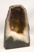 Amethyst geode, a free-standing cut-through specimen displaying a hollow interior cavity lined