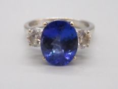 Hallmarked 18ct white gold tanzanite and diamond three-stone ring, set with a central oval-cut