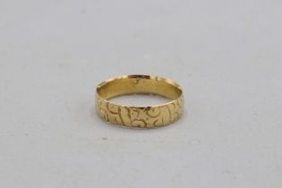 Hallmarked 18ct yellow gold scrollwork-engraved wedding band, 5mm thickness. Size O. Weight 2.95g