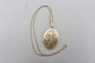 Large hallmarked 9ct yellow gold oval hinged locket with scrollwork-engraved front and fluted