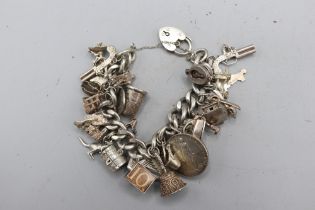 Large, heavy charm bracelet comprising a thick-gauge solid curb link hallmarked sterling silver
