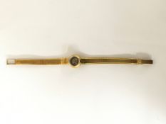 A lady's vintage Omega 18ct gold watch having small domed face on articulated strap.Approx: L6.5 x