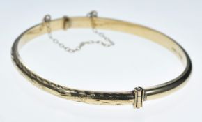 A 9ct gold bangle with cut out decoration, 6.1g