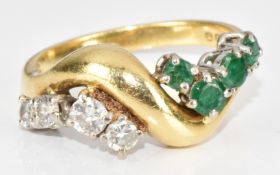 An 18ct gold ring set with four round cut emeralds and four round cut diamonds, the largest