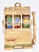 A 9ct gold charm / pendant in the form of a fruit machine, with working lever and wheels, 16.7g, 2.