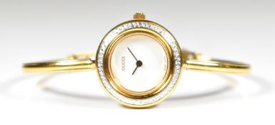 Gucci gold plated ladies wristwatch ref. 11/12.2 with gold hands, white dial, cut steel bezel and
