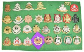 Thirty one cap badges and insignia, five East Surrey including a Victorian example, six North