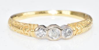 An 18ct gold ring set with three diamonds, with scrolling decoration to the shoulders, 1.9g, size O