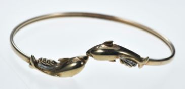 A 9ct gold bangle in the form of two dolphins, 8.2g