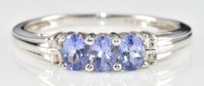 A 9ct gold ring set with three tanzanites and diamonds, 1.8g, size O