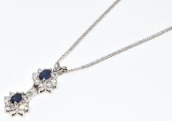 An 18ct white gold pendant set with two oval cut sapphires of approximately 0.4ct and eighteen