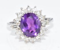 An 18ct white gold ring set with an oval cut amethyst surrounded by round and baguette cut diamonds,