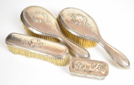 Hallmarked silver dressing table items comprising three hand brushes and a cut glass pot, weight