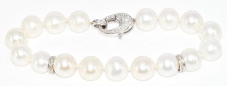 A cultured pearl bracelet with two 18ct white gold spacers, loop and clasp encrusted with
