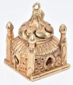 A 9ct gold charm in the form of a temple opening to reveal a man praying, 9.5g, 2 x 1.5cm