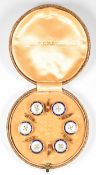 A set of six buttons set with mother of pearl and enamel, with 18ct gold mounts, in original box
