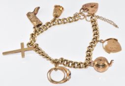 A 9ct gold charm bracelet with six 9ct gold charms including thimble, boot, cross, kettle, rings and