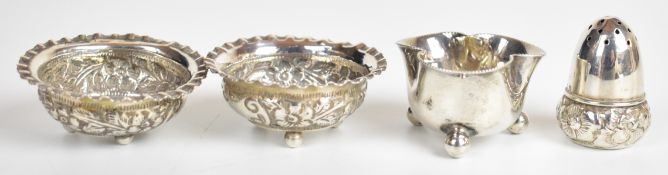 Pair of Victorian hallmarked silver salts with embossed decoration and raised on three ball feet,