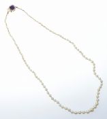 A single strand of graduated cultured pearls with 18k gold clasp set with an amethyst surrounded