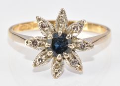 An 18ct gold ring set with a round cut sapphire surrounded by diamonds in a flower cluster, 3.5g,