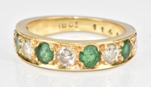 An 18ct gold half eternity ring set with round cut emeralds and diamonds, the largest emerald 0.25ct