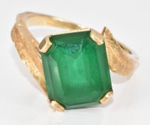 A 14k gold ring set with an emerald cut green paste stone, 4.6g, size O