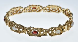 A 9ct gold bracelet set with opal cabochons and oval cut garnets, 19.5g, 19.5cm