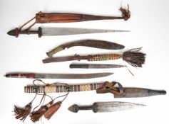 Four North African knives / short swords in tooled and worked leather scabbards, and a Gurkha