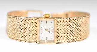 Omega 9ct gold ladies wristwatch with black hands and baton hour markers, silver dial and signed