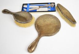George V hallmarked silver dressing table set comprising hand mirror and two brushes, Birmingham