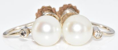 A pair of 14k white gold earrings each set with a pearl and diamond, 2g