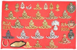 Thirty four military cap badges and shoulder titles including seventeen Royal Artillery and Royal