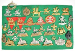 Approximately thirty four cap badges and insignia including Liverpool Pals, Royal Warwickshire
