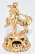 A 9ct gold charm in the form of a horse set with onyx, 7.8g, 3.1cm