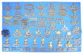 Approximately 62 brass military shoulder titles and insignia including six Officer Training Colleges