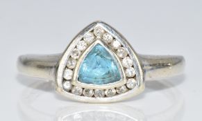 A 9ct white gold ring set with a trillion cut topaz surround by diamonds, 2.8g, size S