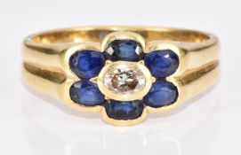 An 18ct gold ring set with an oval cut diamond surrounded by oval cut sapphires, 4.1g, size M