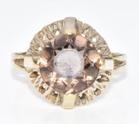 A 333 gold ring set with a round cut smoky quartz within a textured pierced border, 3.7g, size L/M