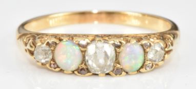 Victorian yellow metal ring (tests as 18ct) set with three old cut diamonds and two opals, 2.2g,