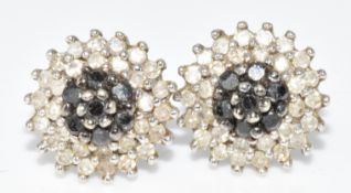 A pair of 9ct white gold earrings set with black diamonds and white diamonds in a cluster, 1.8g