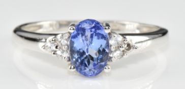 A 9ct white gold ring set with an oval cut tanzanite and diamonds, 2.1g, size O (one diamond