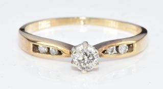 A 9ct gold ring set with a round cut diamond of approximately 0.15ct and with further diamonds to