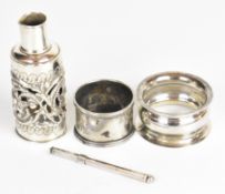 Two hallmarked silver napkin rings, hallmarked silver glass bottle cover with embossed and pierced