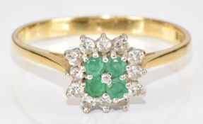 An 18ct gold ring set with four round cut emeralds surrounded by diamonds, 2.9g, size R